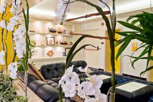 a living room with a couch and some plants at Hotel Montecarlo in Bibione