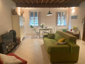 een woonkamer met een groene bank en een tafel bij Casa Amorino in Lucca