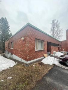 a brick house with a car parked in front of it at Nice and cozy big house for 8 people with sauna in Vantaa