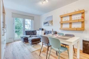 ein Wohnzimmer mit einem Tisch, Stühlen und einem Sofa in der Unterkunft Ferienwohnung AHOI in Norderney