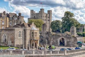 um velho castelo com carros estacionados em frente em Quantock Lodge Vicarage 1 em Rochester