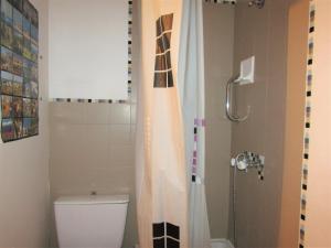 La salle de bains est pourvue de toilettes et d'un rideau de douche. dans l'établissement MER indigo & FLAMANTS Roses, à Mauguio