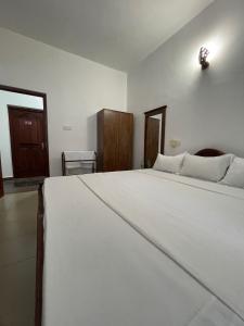 a bedroom with a large white bed in a room at The Ocean Pearl Resorts in Panadura