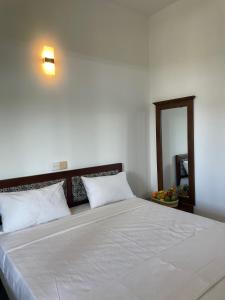a bedroom with a large bed with white sheets at The Ocean Pearl Resorts in Panadura