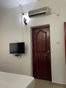 a room with a door and a flat screen tv at The Ocean Pearl Resorts in Panadura