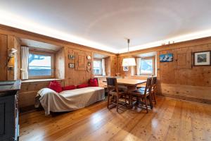 a bedroom with a bed and a table and chairs at Apartments Frea - Vedl Luech da Plajes in Ortisei