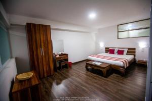 um quarto de hotel com uma cama e uma mesa em Grand Appart'Antaninarenina em Antananarivo