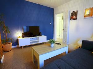 uma sala de estar com um sofá e uma televisão em Pass the Keys King Bed House Next To Heaton Park WM Discounts em Manchester