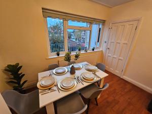 een eetkamer met een tafel en stoelen en een raam bij Large 4 bedrooms golders green in Londen