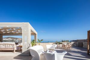 a patio with white chairs and a view of the ocean at Villa Moana in Balíon