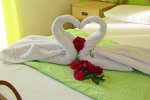Zwei Schwäne, die wie Herzen auf einem Bett aussehen in der Unterkunft Coralli Rooms & Restaurant in Elafonisos