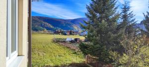 a window with a view of a field and mountains at Apartman Svalina in Kupres