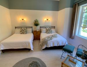a bedroom with two beds and a window at Dale Court Guest House in Cape Town
