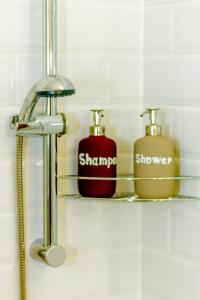 een badkamerplank met twee zeepdispensers erop bij Peony Káldy Apartman Free Garage under the house in Boedapest