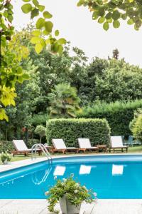 een zwembad met 2 ligstoelen bij Ristorante Albergo Ca' Vittoria in Tigliole