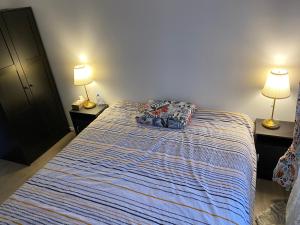 1 dormitorio con 1 cama con 2 lámparas en 2 mesas en Room close to Arena La Défense paris en Nanterre
