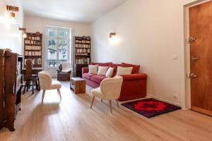 een woonkamer met een rode bank en stoelen bij Majestic - Appartement 2 pas du centre-ville Chamo in Chamonix-Mont-Blanc