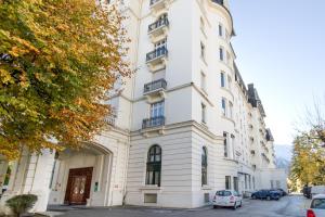 een wit gebouw met auto's ervoor geparkeerd bij Majestic - Appartement 2 pas du centre-ville Chamo in Chamonix-Mont-Blanc