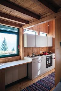 una cocina con armarios blancos y una ventana en Bregenzerwald Ferienhaus, en Egg