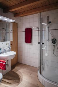 W łazience znajduje się prysznic, umywalka i wanna. w obiekcie Bregenzerwald Ferienhaus w mieście Egg