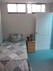 a bedroom with a bed and a door with windows at Terraza más habitaciones en La Molina in Lima