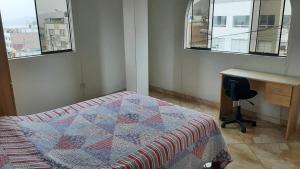 Terraza más habitaciones en La Molina في ليما: غرفة نوم بسرير ومكتب ونوافذ
