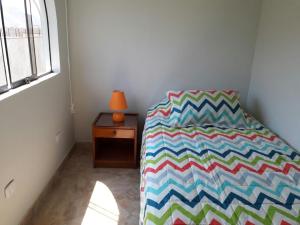 um quarto com uma cama com um edredão colorido em Terraza más habitaciones en La Molina em Lima