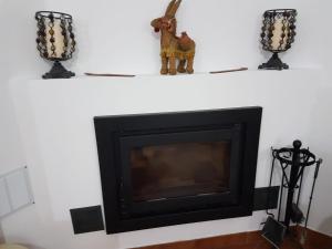 a fireplace on a white shelf with two candles at Casa Rural Maestre in Vilches