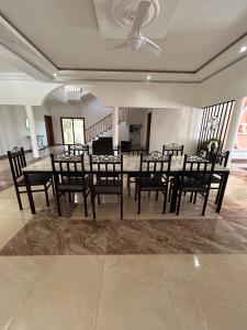 uma sala de jantar com uma mesa e cadeiras pretas em Zarafah em Poponguine