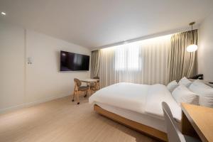 una camera d'albergo con letto e scrivania di HOTEL SOHA a Gumi