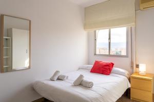 two beds in a room with a mirror and a window at Malaga Grandview Retreat in Málaga