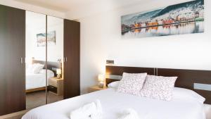 a bedroom with a white bed and a painting on the wall at Malaga Grandview Retreat in Málaga