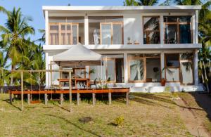 una casa con una mesa y una sombrilla delante de ella en Canto das Amêijoas, en Inhambane