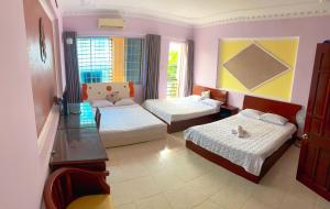 a living room with two beds and a table at OYO 1212 Uyen Phuong Motel in Vung Tau