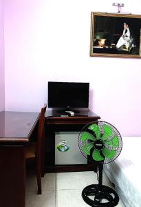 a desk with a fan and a desk with a laptop at OYO 1212 Uyen Phuong Motel in Vung Tau