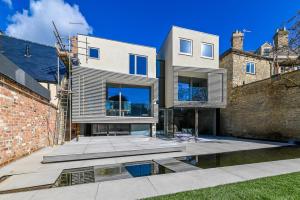 a house with a courtyard in front of a brick wall at Contemporary home in historic town in Woodstock