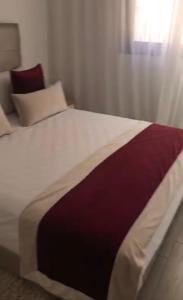 1 cama grande con manta blanca y burdeos en Apartamento ik en marrakech, en Marrakech