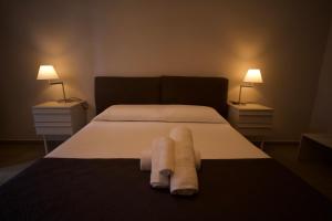 Donna Franca Rooms and Suite في باليرمو: غرفة نوم مع منشفتين على سرير مع مصباحين