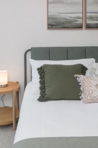 łóżko z białą pościelą i poduszkami oraz stołem w obiekcie Posh Perch on Collins - A Cosy Couple's Haven w Melbourne