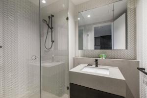 y baño con lavabo, ducha y espejo. en Aloft on Collins - Skyline Views from the 53rd Floor en Melbourne
