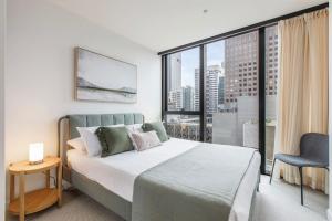 a bedroom with a bed and a large window at Elevated Elegance - A Fusion of Style and Comfort in Melbourne