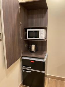 uma cozinha com um micro-ondas e um pequeno frigorífico em Adobe Suites em Salta