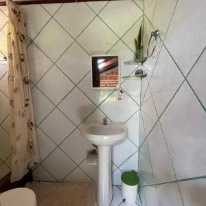 uma pequena casa de banho com um lavatório e um espelho em KauMaê em Santa Cruz Cabrália