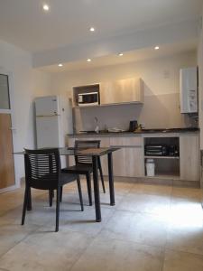 a kitchen with a table and two chairs and a refrigerator at Yunka Alquiler temporario, Salta, Vaqueros in Vaqueros