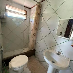 łazienka z toaletą i umywalką w obiekcie KauMaê w mieście Santa Cruz Cabrália