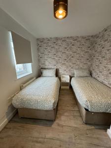 a bedroom with two beds and a wall at ane in Peterborough