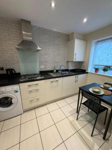 a kitchen with a stove and a sink and a table at ane in Peterborough