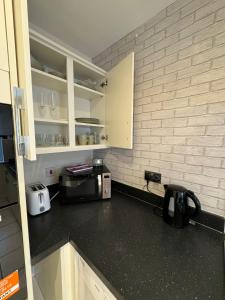 a kitchen with a counter top with a microwave at ane in Peterborough