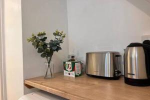 eine Theke mit zwei Toaster und einer Vase aus Blumen in der Unterkunft Cosy One Bedroom Apartment in Exeter