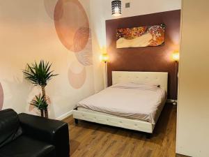 a small bedroom with a bed and a couch at Venice Loft with balcony downtown in Kraków